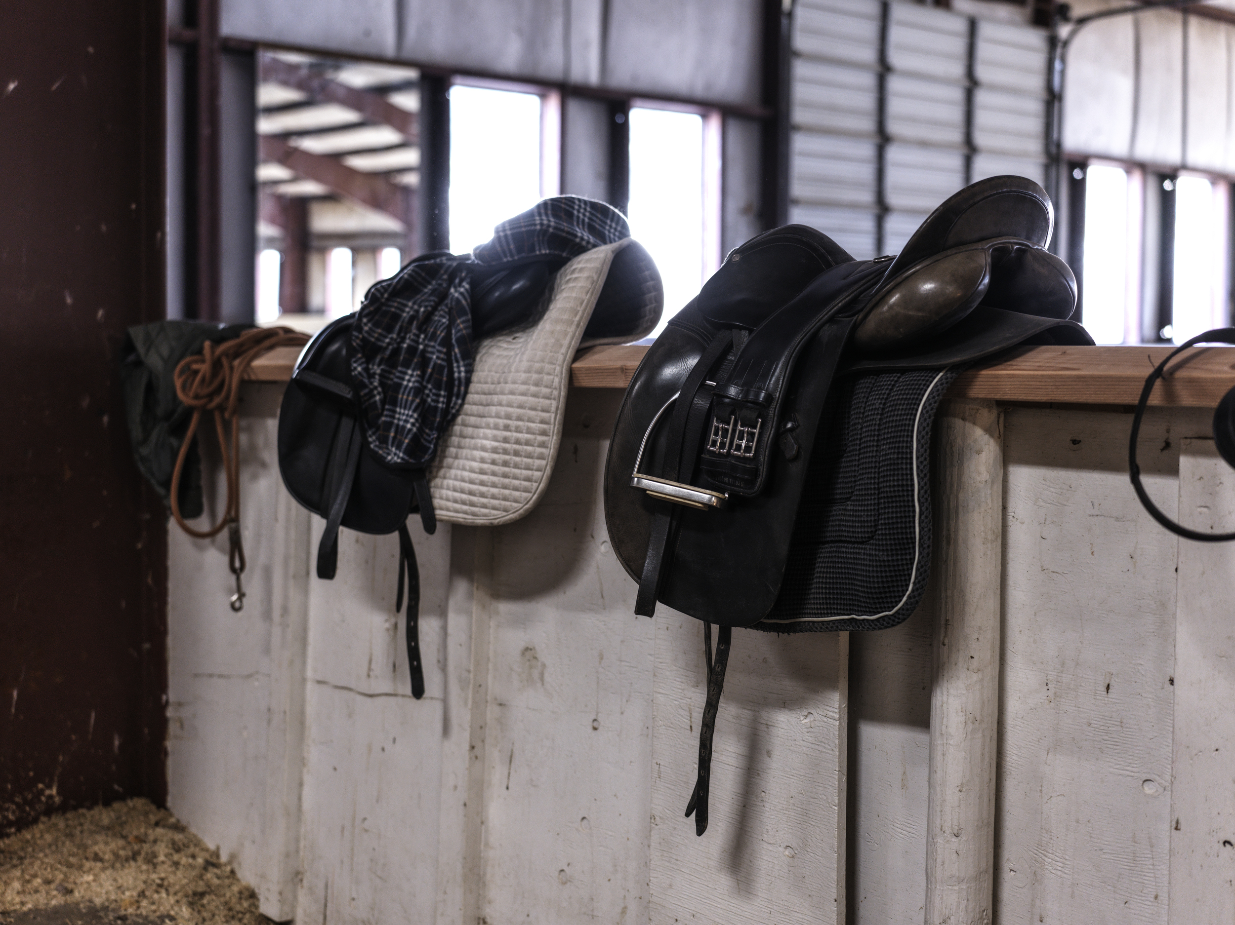 Indoor arena with walls to hold saddles and tack